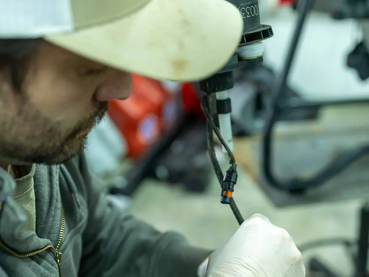 A RADS technician repairs a drone arm at the service bench in the RADS shop