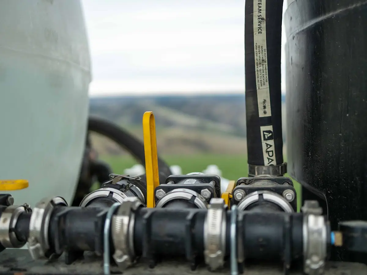 Camlock fittings, valves and hose on the chemical tank of a RADS spray platform